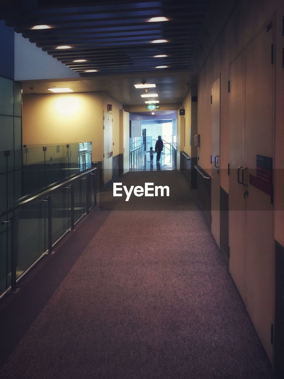 PEOPLE WALKING IN ILLUMINATED BUILDING