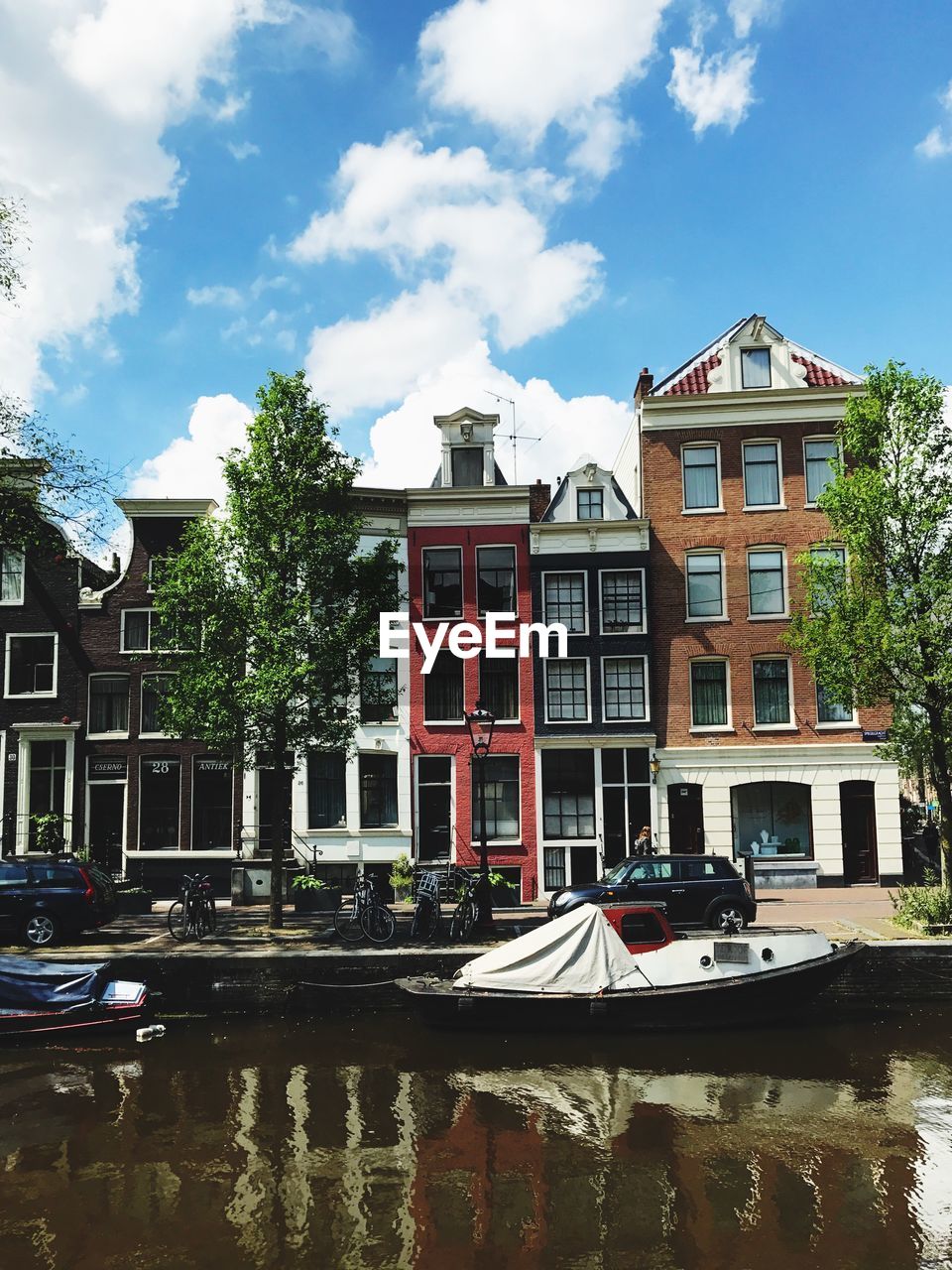 Boats moored by buildings in city against sky