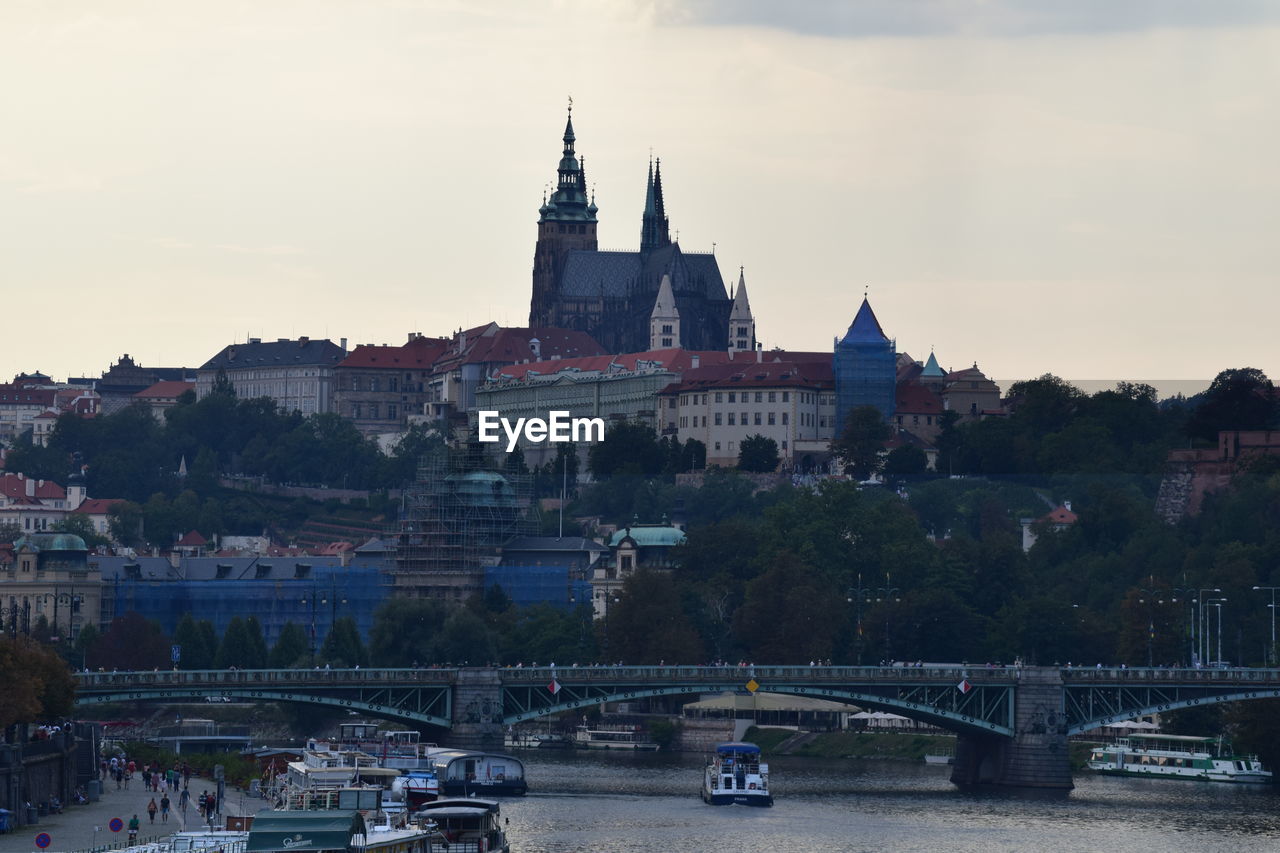 Bridge over river in city against sky