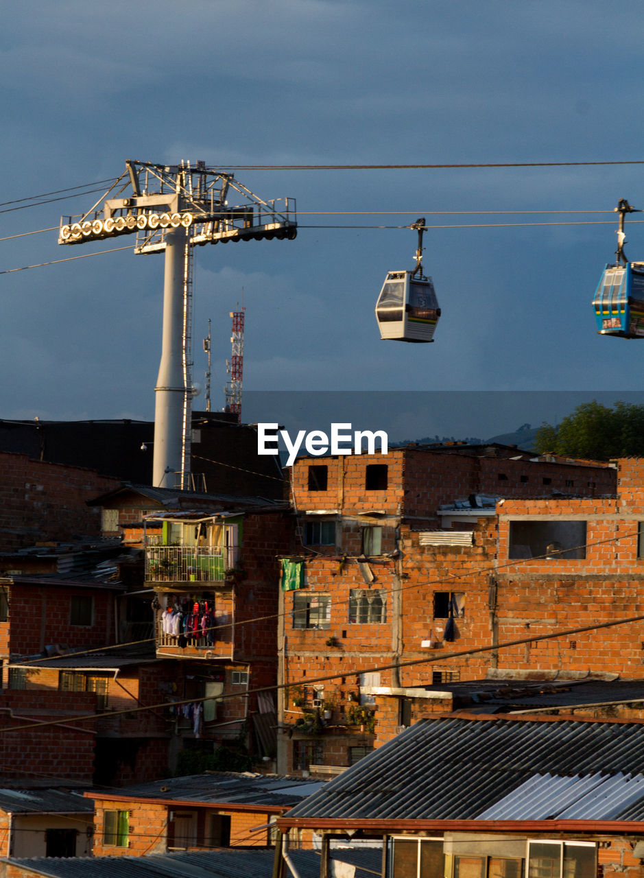 Cable cars over residential district against sky