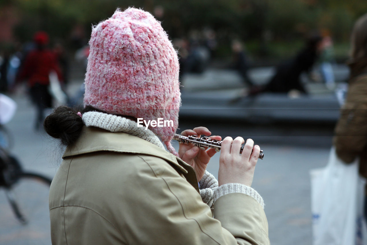 Rear view of woman playing flute