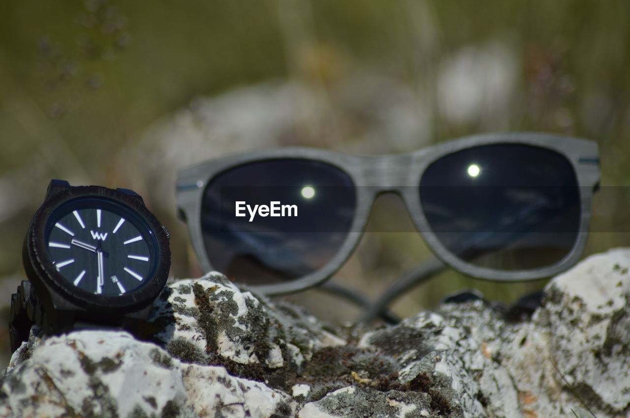 CLOSE-UP OF SUNGLASSES ON WOODEN WALL