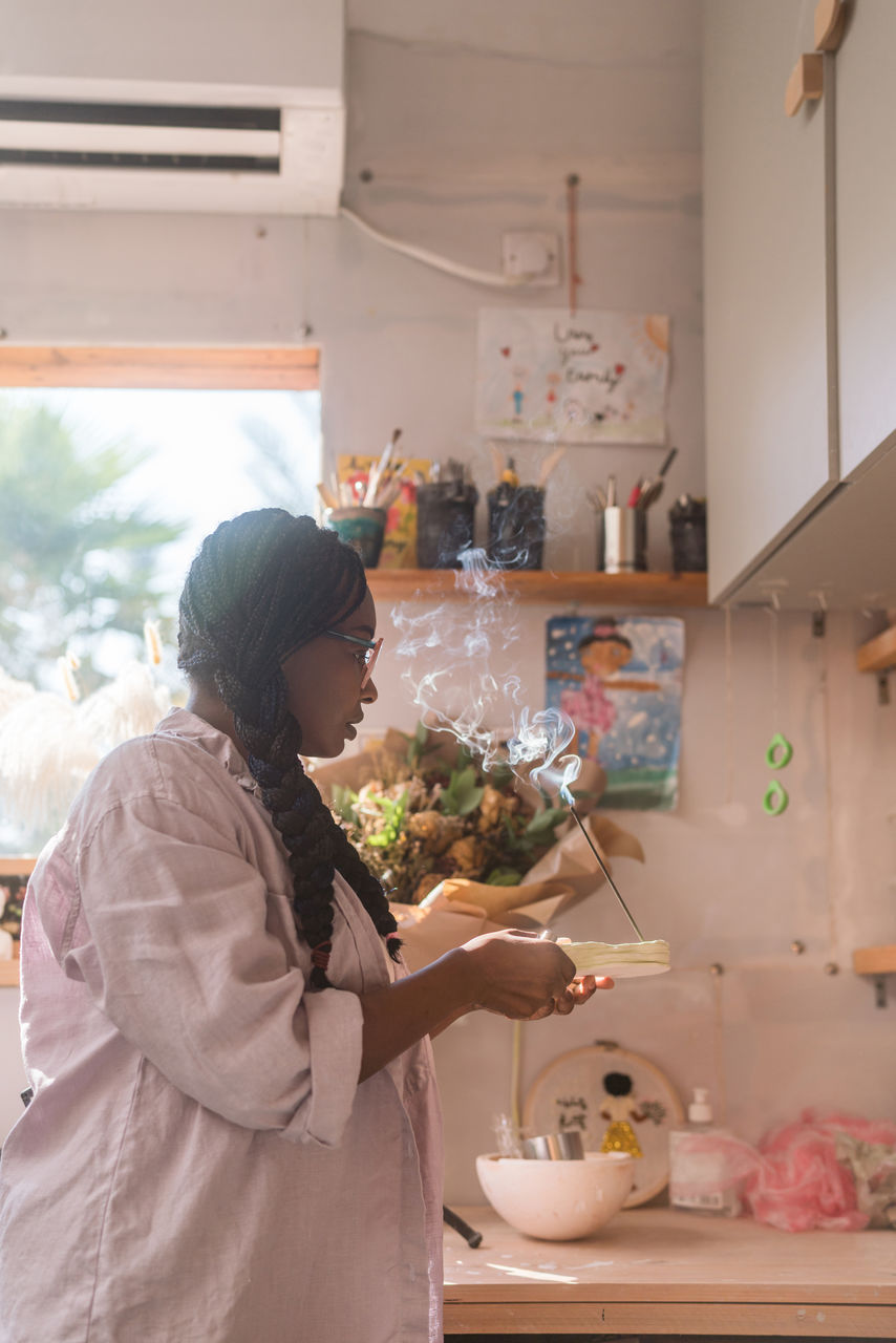 Woman with braided hair lighting up incense