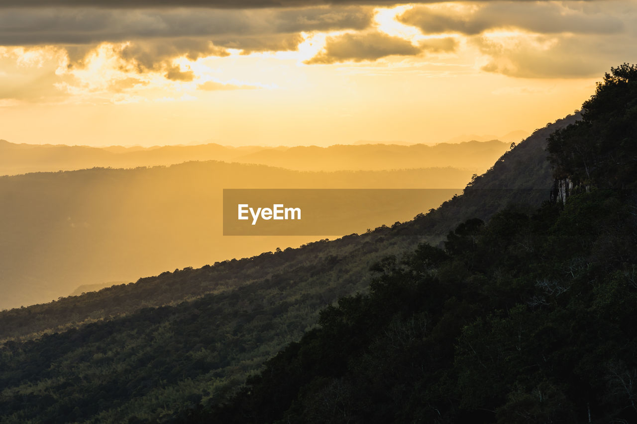 SCENIC VIEW OF MOUNTAINS AGAINST ORANGE SKY