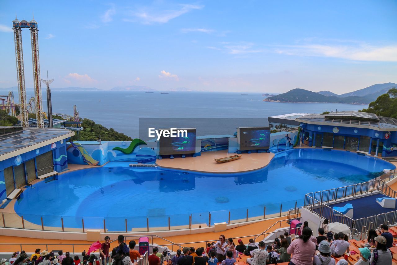 HIGH ANGLE VIEW OF PEOPLE SWIMMING IN POOL