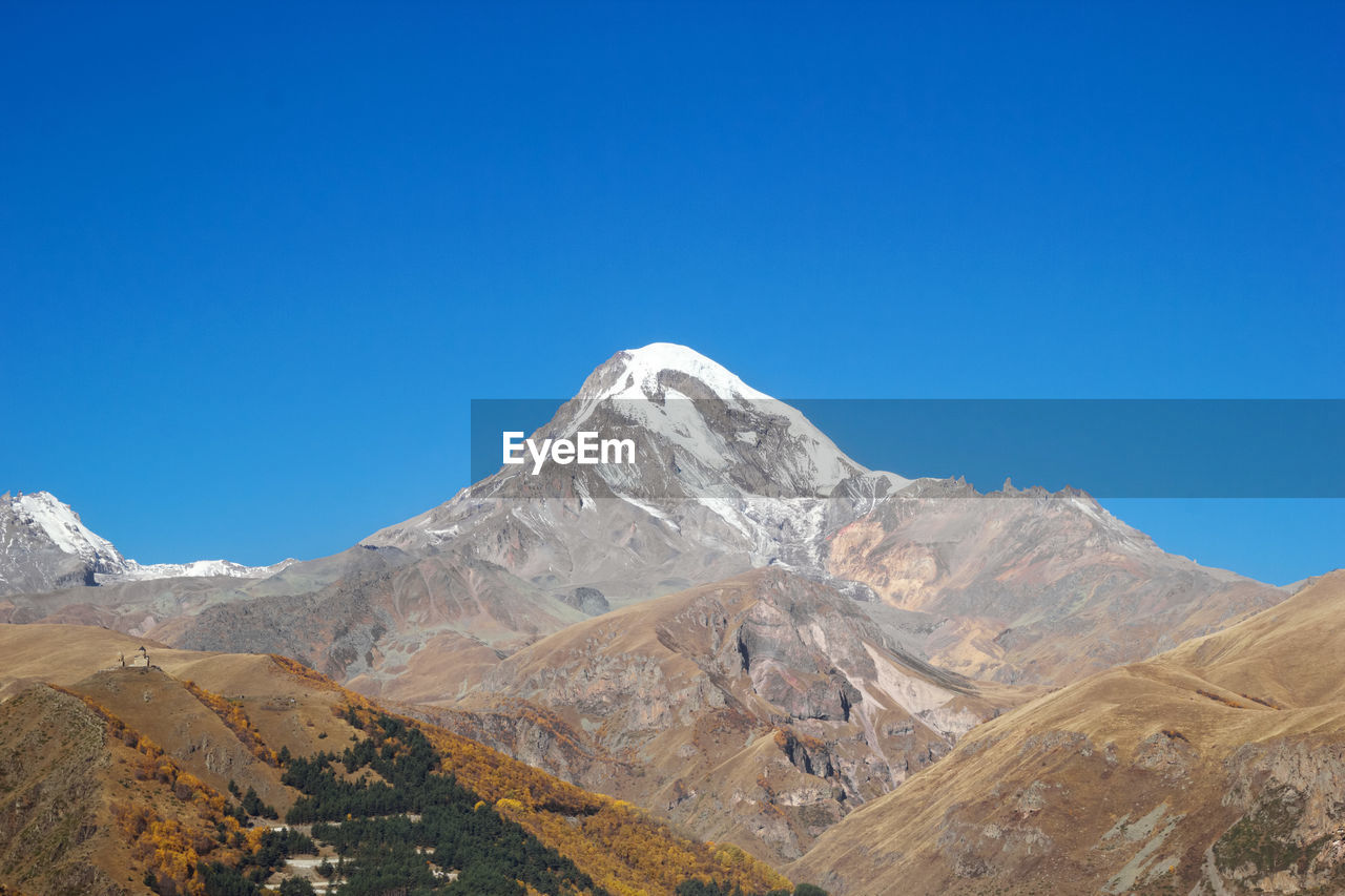 View of mount kazbek in the greater caucasus mountains of georgia in autumn time.