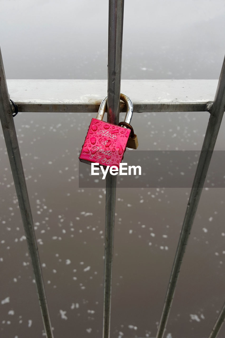 CLOSE-UP OF PINK UMBRELLA AGAINST LAKE