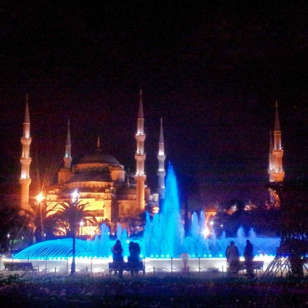 TOURISTS AT NIGHT SEEN THROUGH ARCH