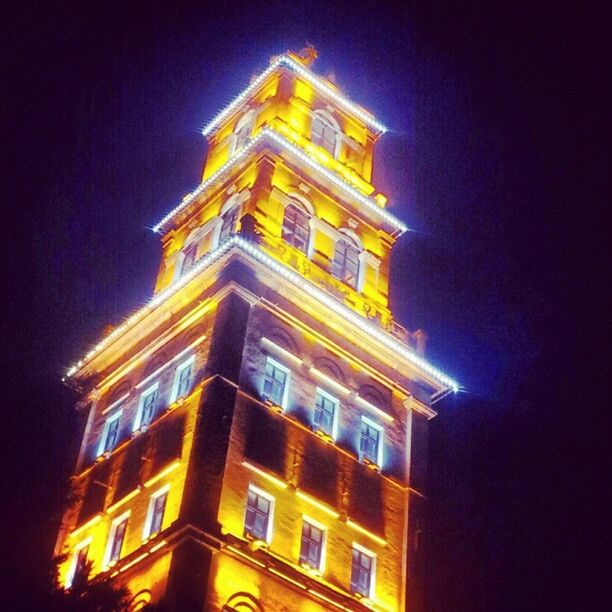 LOW ANGLE VIEW OF ILLUMINATED BUILDING AT NIGHT