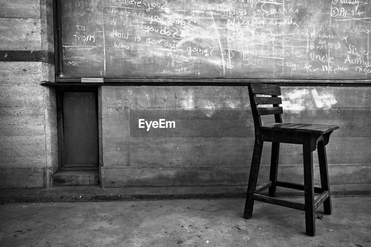 EMPTY CHAIRS AND TABLE IN ABANDONED BUILDING