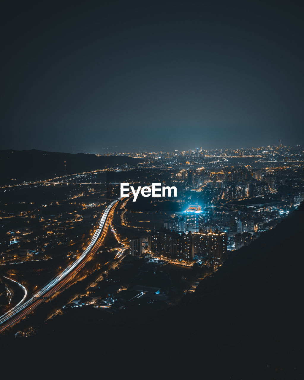 High angle view of illuminated cityscape against sky at night