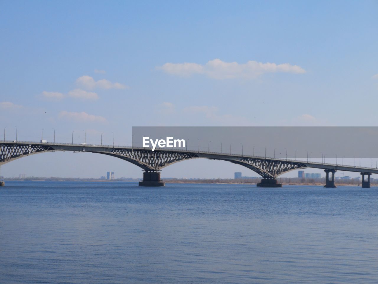 Bridge over calm sea against sky