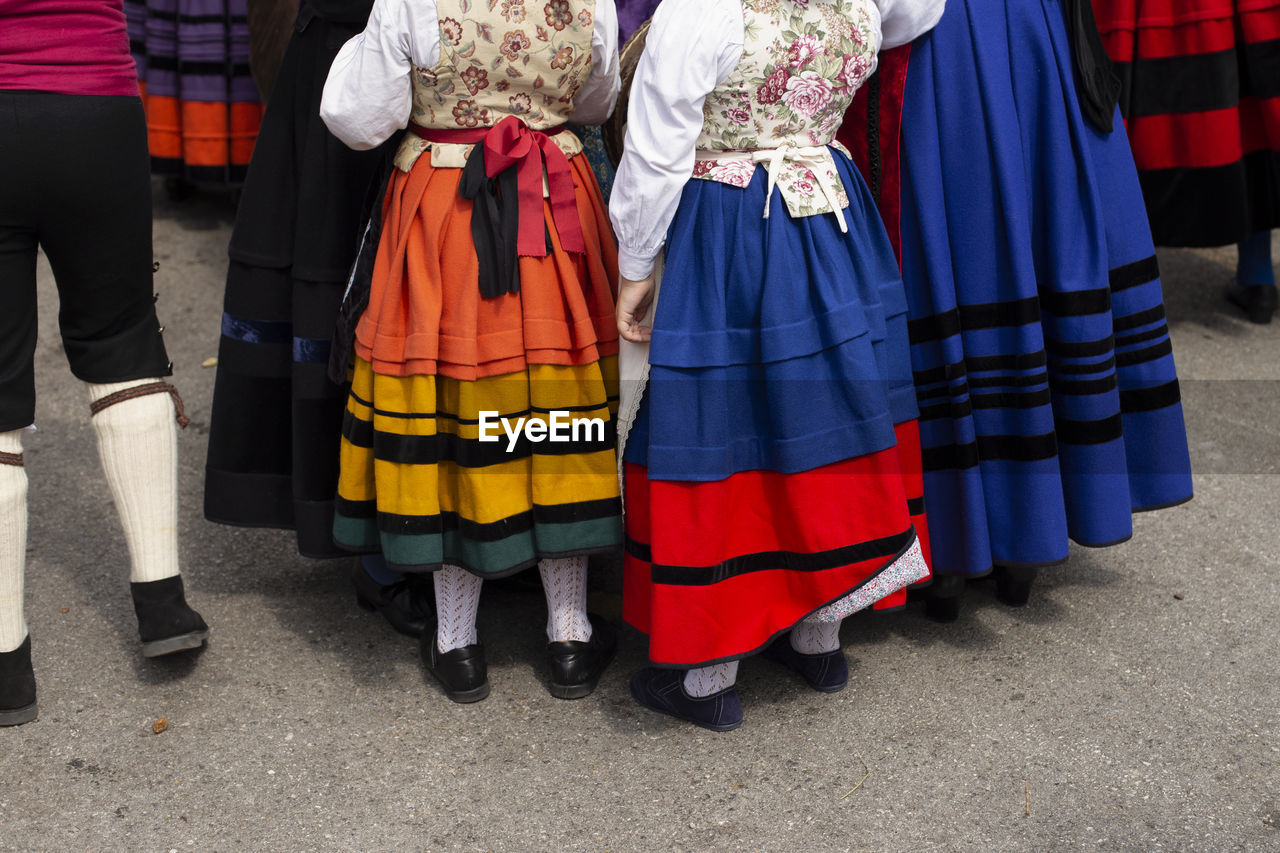 Low section of people in traditional clothing standing on road