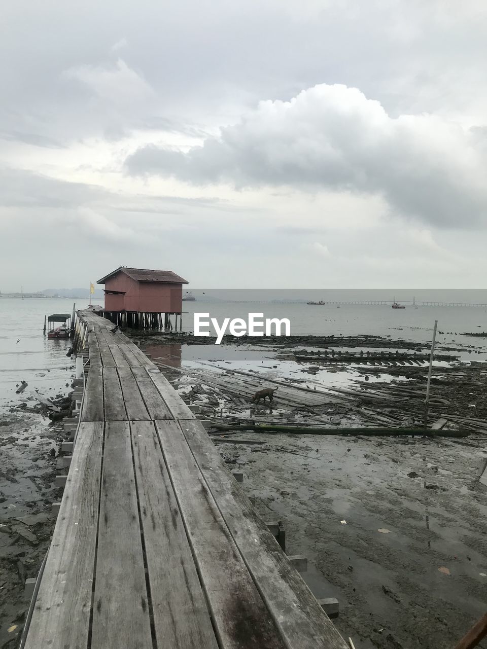 water, sky, sea, cloud, pier, coast, beach, wood, architecture, nature, land, shore, built structure, ocean, scenics - nature, beauty in nature, hut, tranquility, no people, building exterior, day, horizon, horizon over water, boardwalk, tranquil scene, jetty, travel destinations, outdoors, travel, holiday, walkway, building, transportation, environment, sand, non-urban scene, vacation, coastline, tourism, trip, overcast, nautical vessel