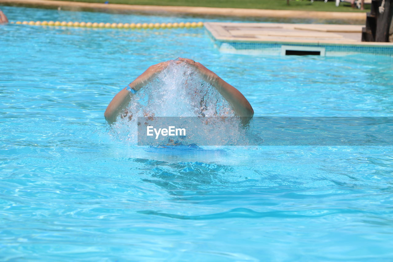 Person gesturing in swimming in pool