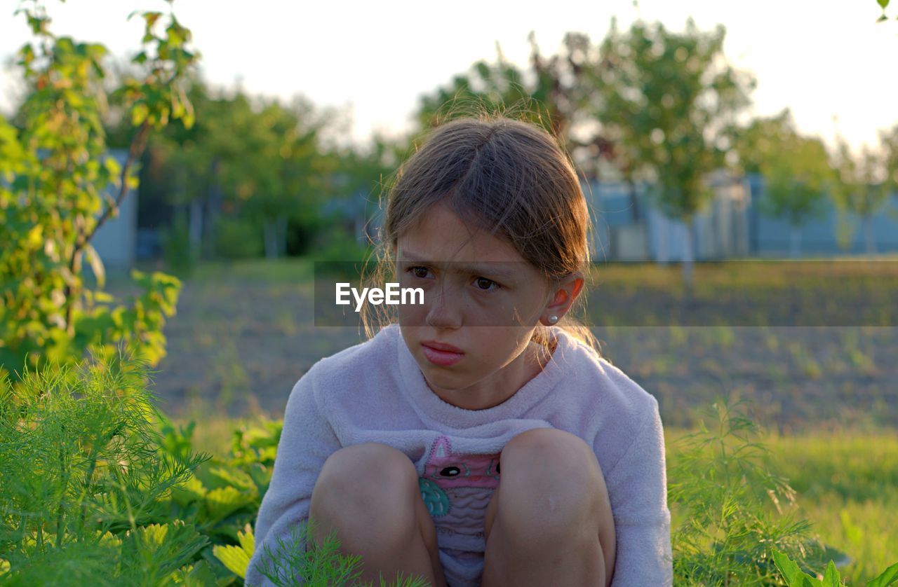 Portrait of girl sitting on field