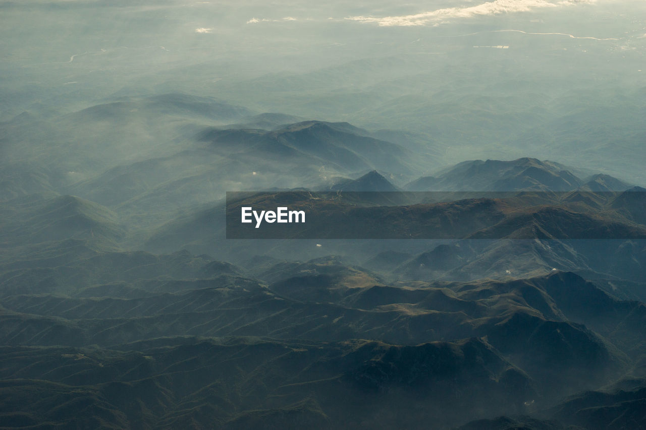 SCENIC VIEW OF SEA AGAINST MOUNTAINS