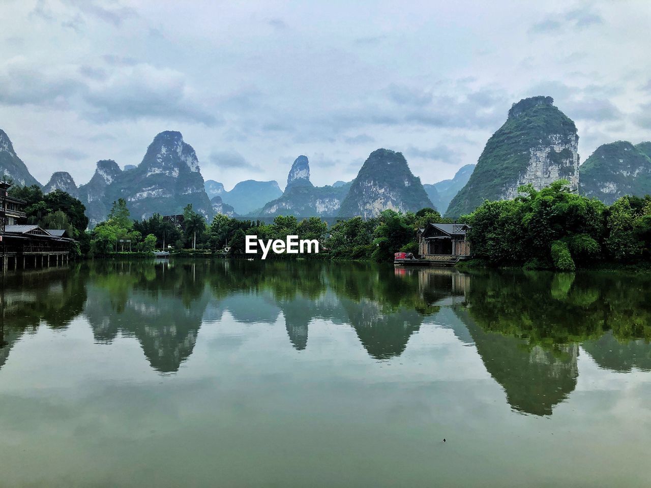 reflection, water, mountain, lake, scenics - nature, mountain range, beauty in nature, sky, nature, tranquility, landscape, cloud, environment, architecture, tree, travel destinations, building, reservoir, tranquil scene, no people, travel, built structure, plant, outdoors, tourism, building exterior, reflection lake, house, religion, land, idyllic