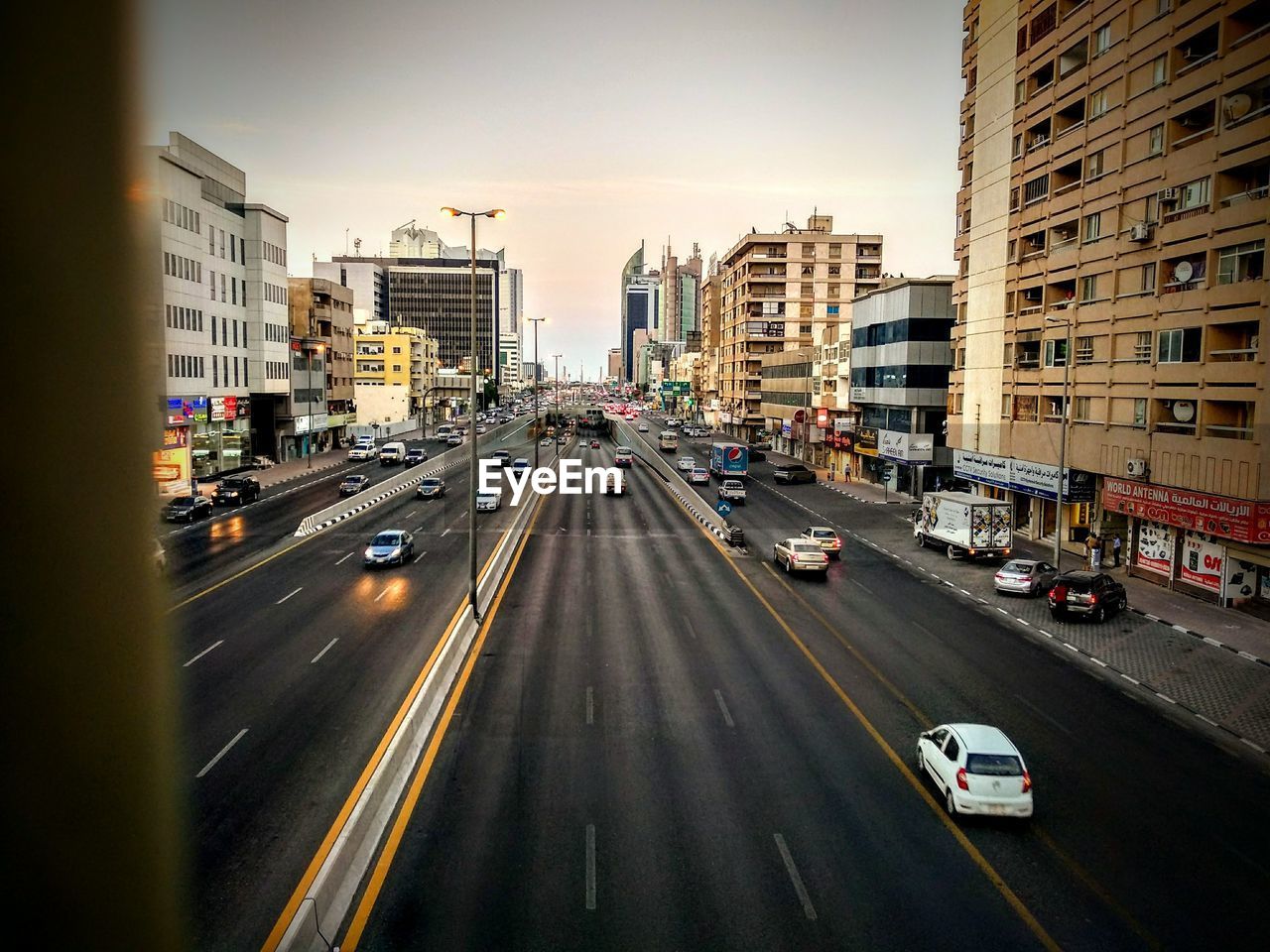 Cars on road in city seen through window