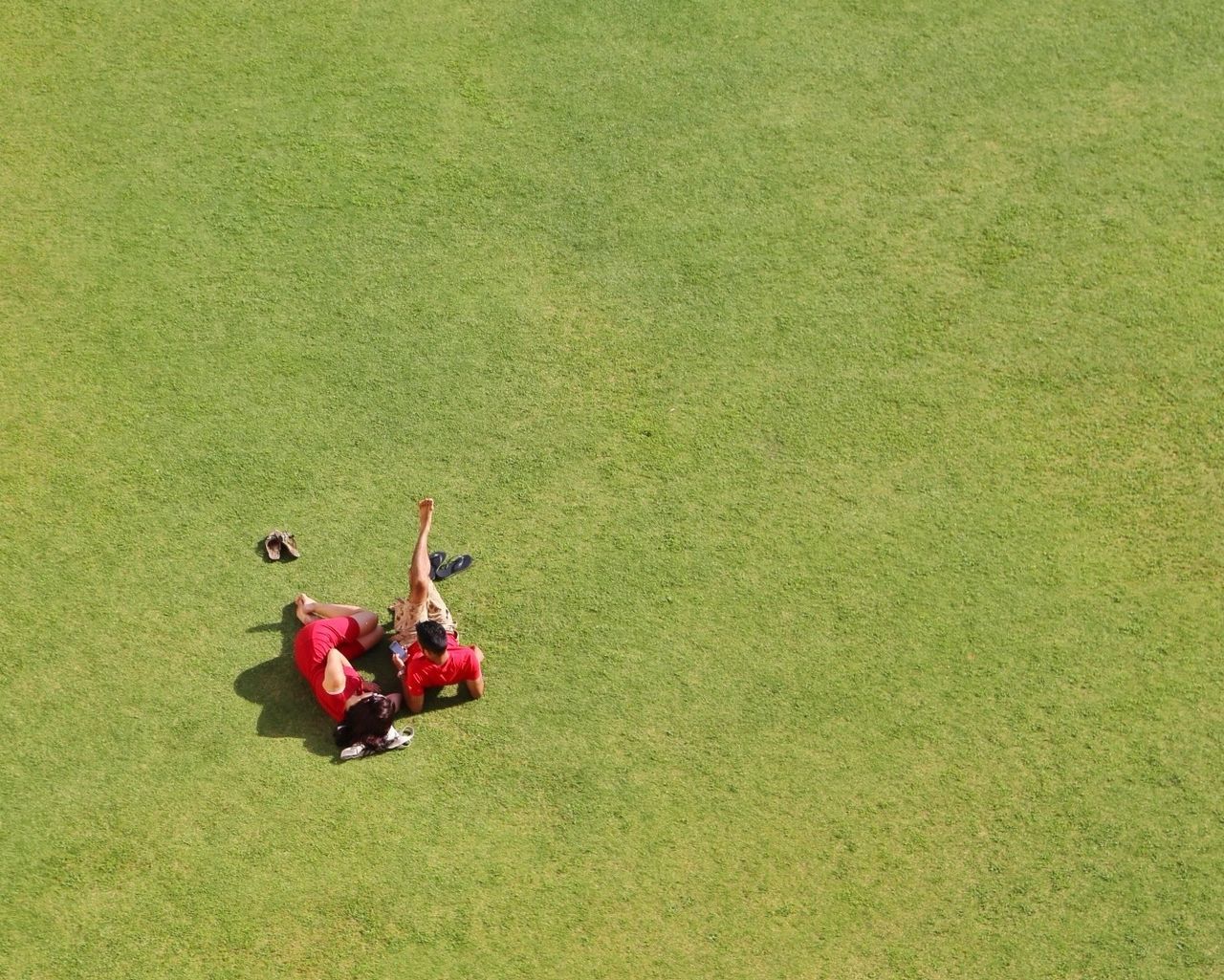 High angle view of people relaxing on field in park during sunny day