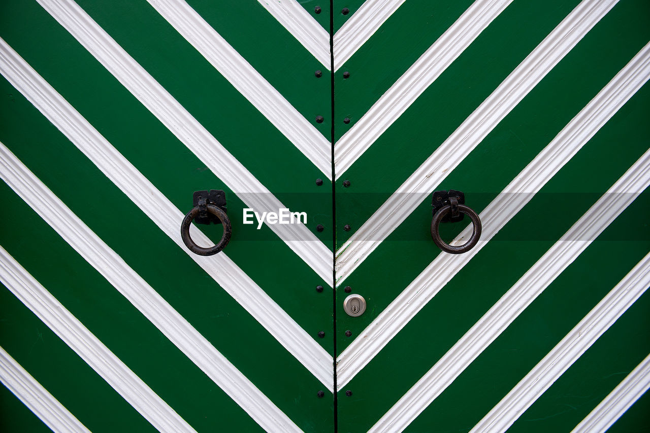 Ring knockers on green door