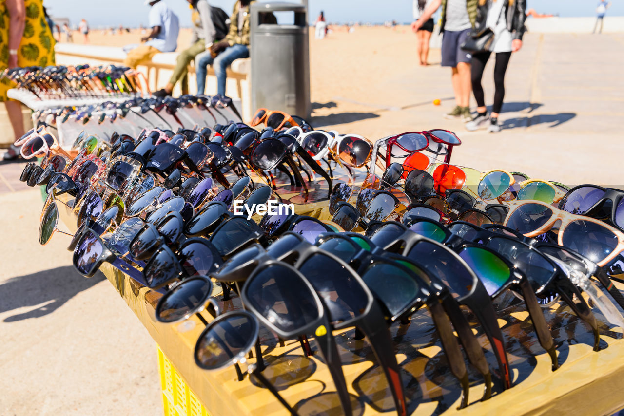 Close-up of sunglasses for sale by people at beach