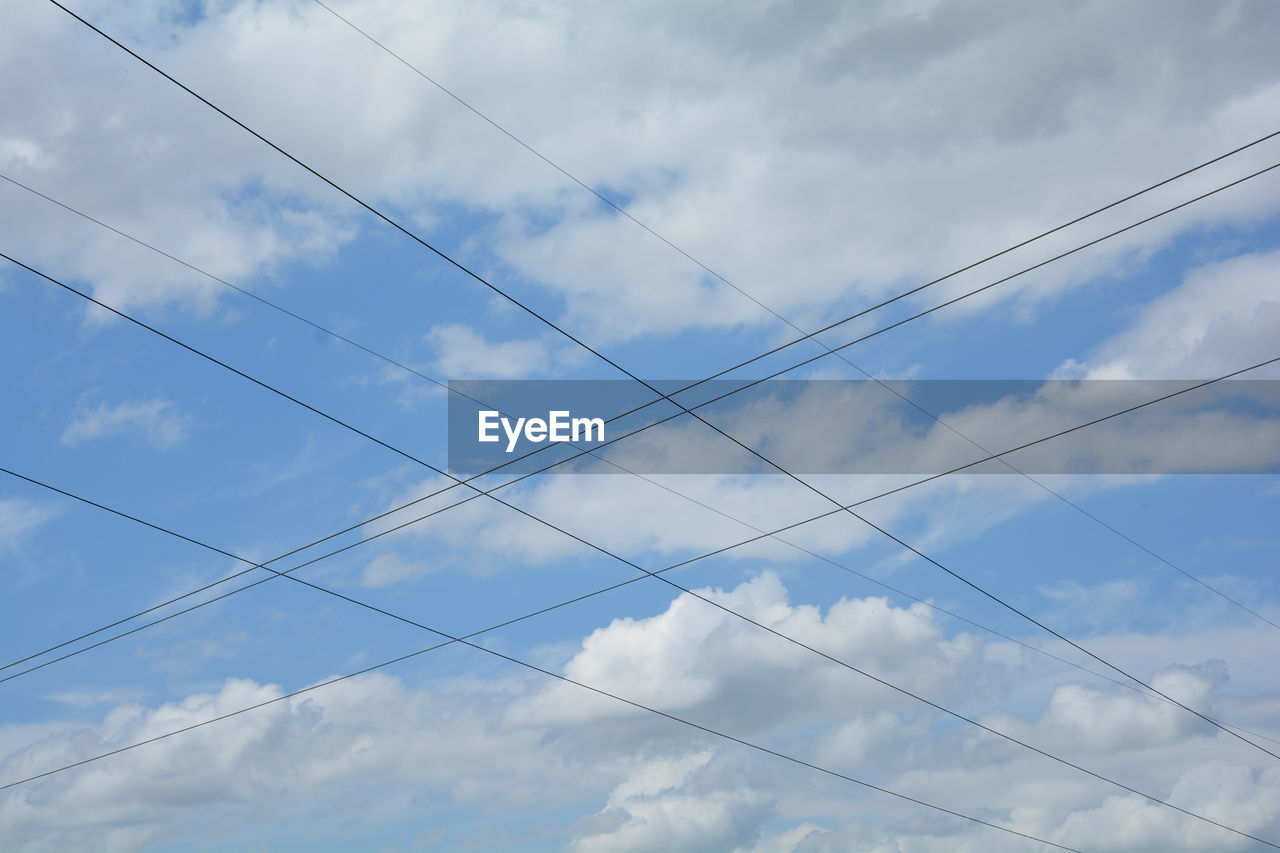 Low angle view of cables against cloudy sky