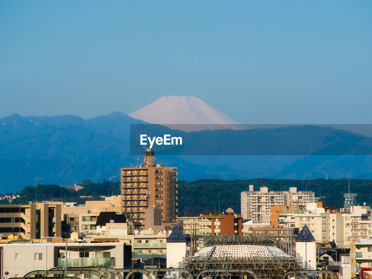 Buildings in city against blue sky