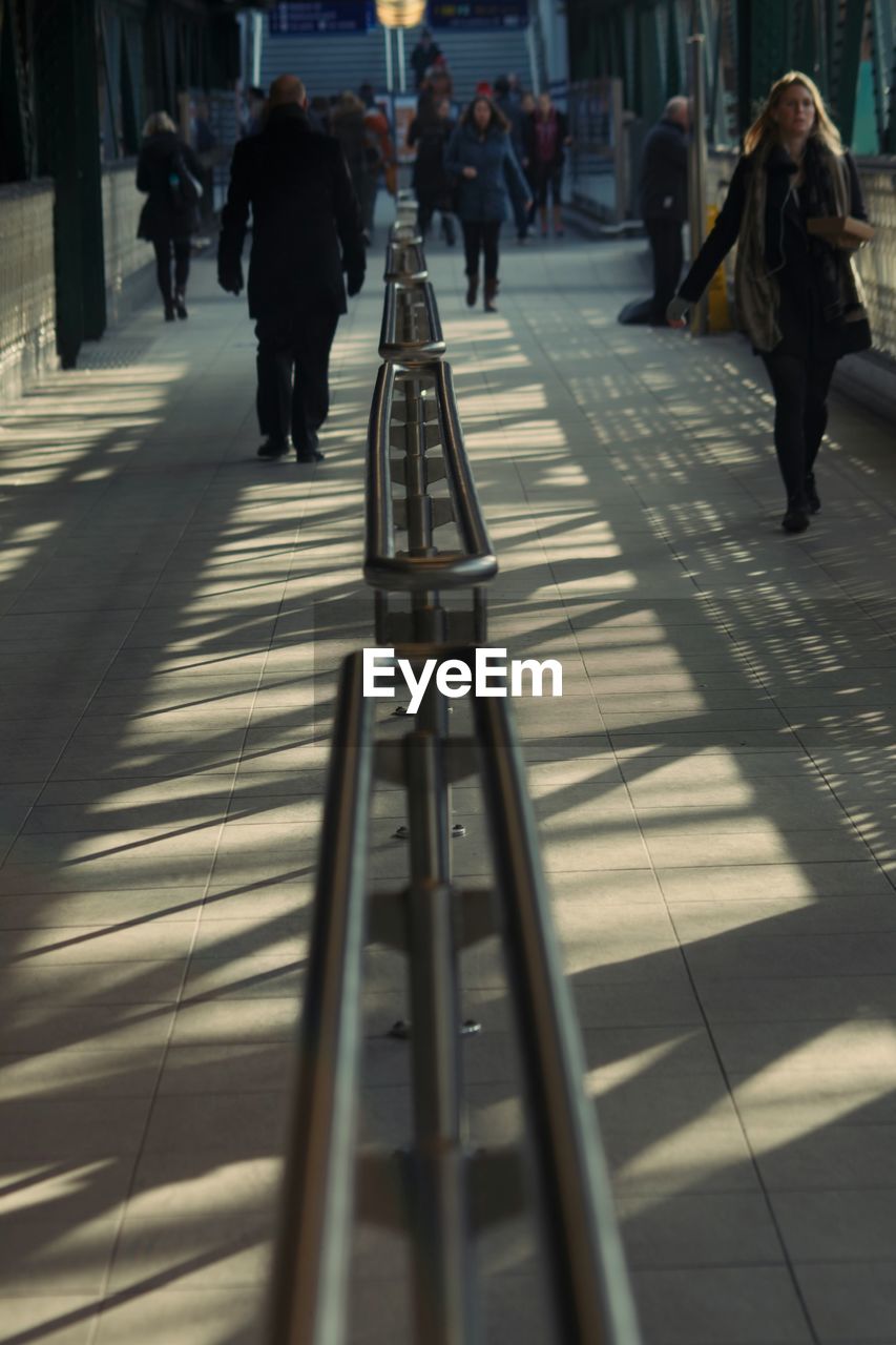 PEOPLE WALKING ON ROAD IN CITY