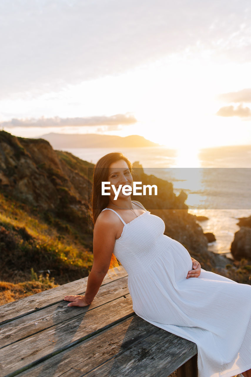 Portrait of smiling woman against sky during sunset