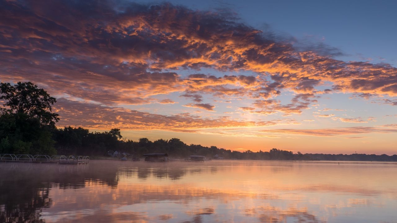 Scenic view of sea against cloudy sky during sunset