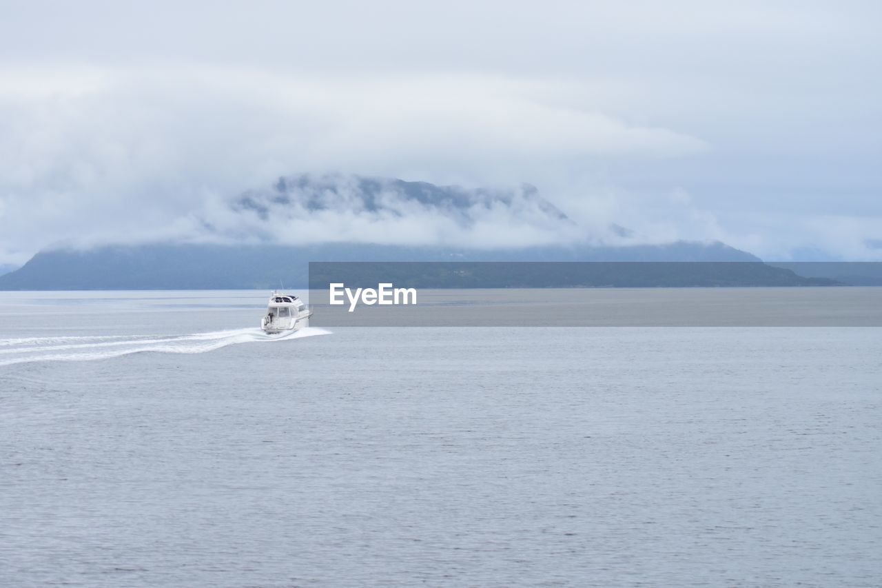 Boat sailing on sea against sky