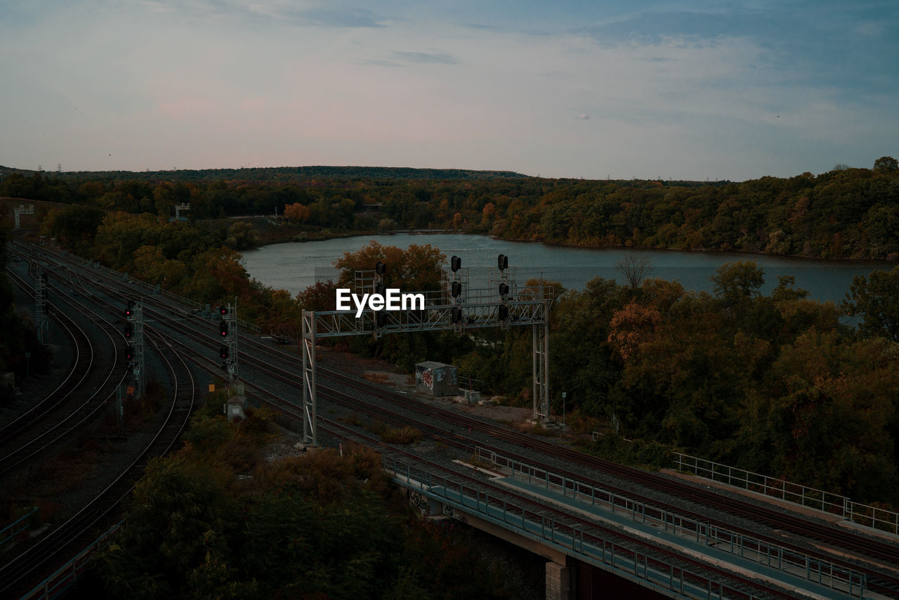 HIGH ANGLE VIEW OF RAILROAD TRACKS AMIDST TREES AGAINST SKY