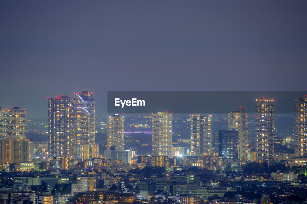 Illuminated cityscape against clear sky at night