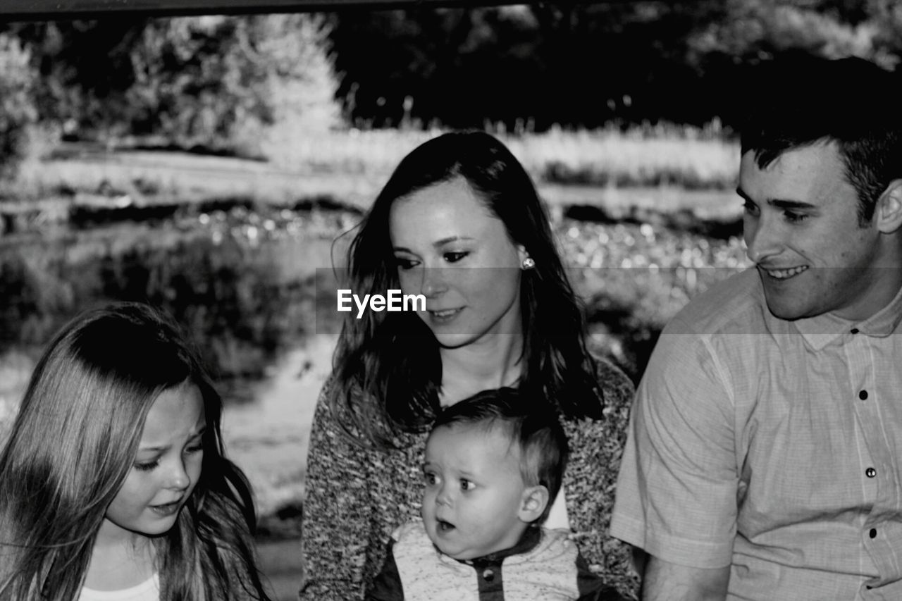 Smiling family looking at girl in public park