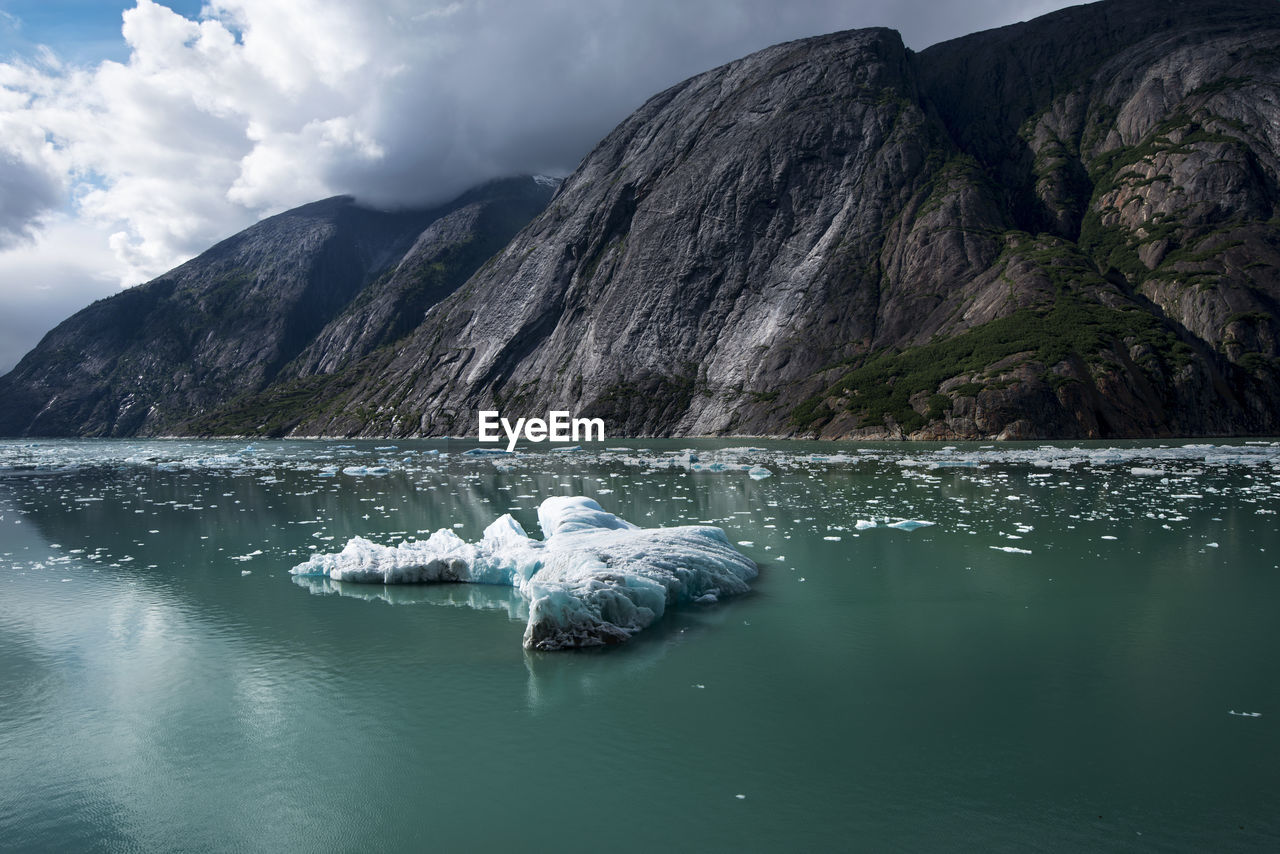 Scenic view of an iceberg and mountains in alaska