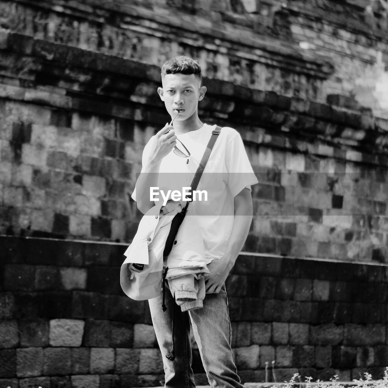 Young man standing against wall