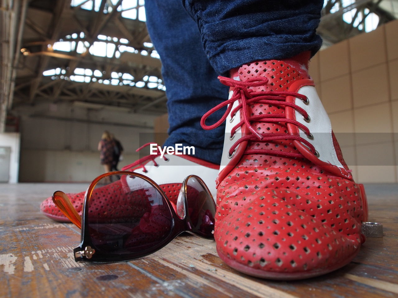 Close-up of person wearing red and white shoes on floor