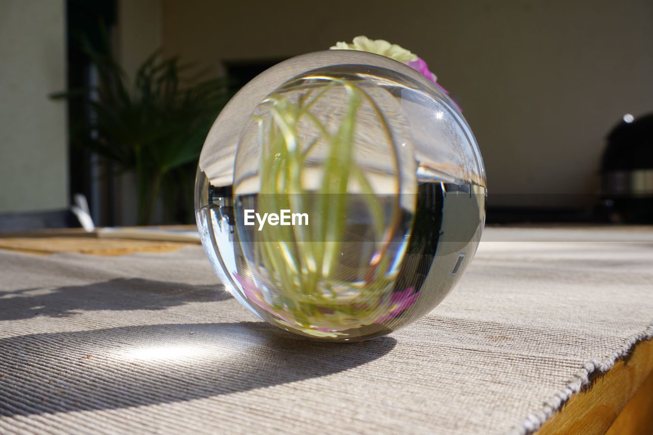 Close-up of crystal ball on glass table