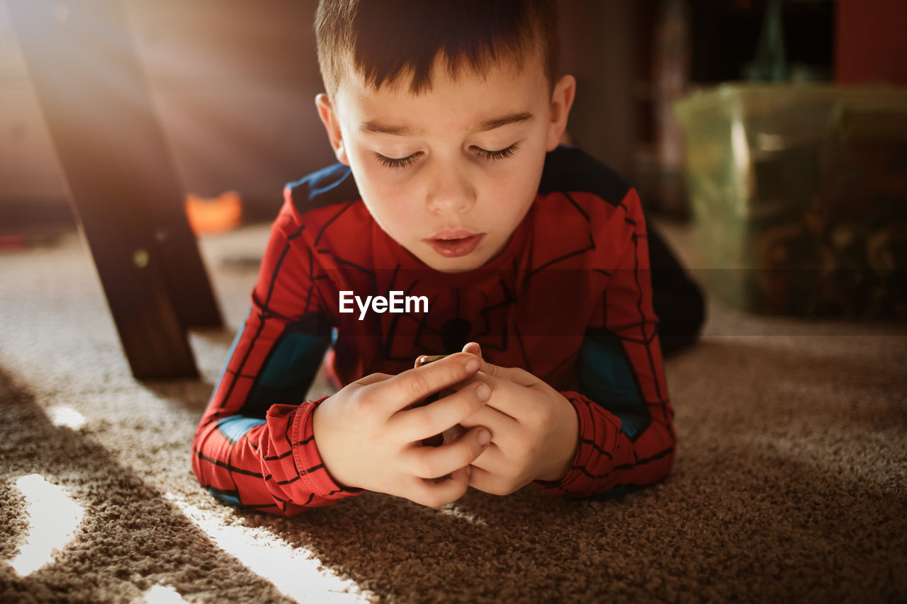 Boy looking at camera while sitting on mobile phone