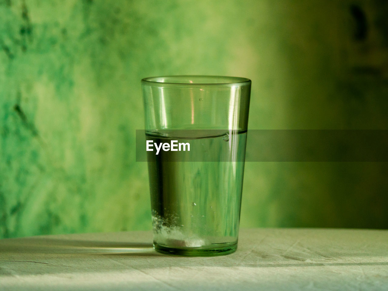 CLOSE-UP OF GLASS OF WATER ON TABLE IN KITCHEN