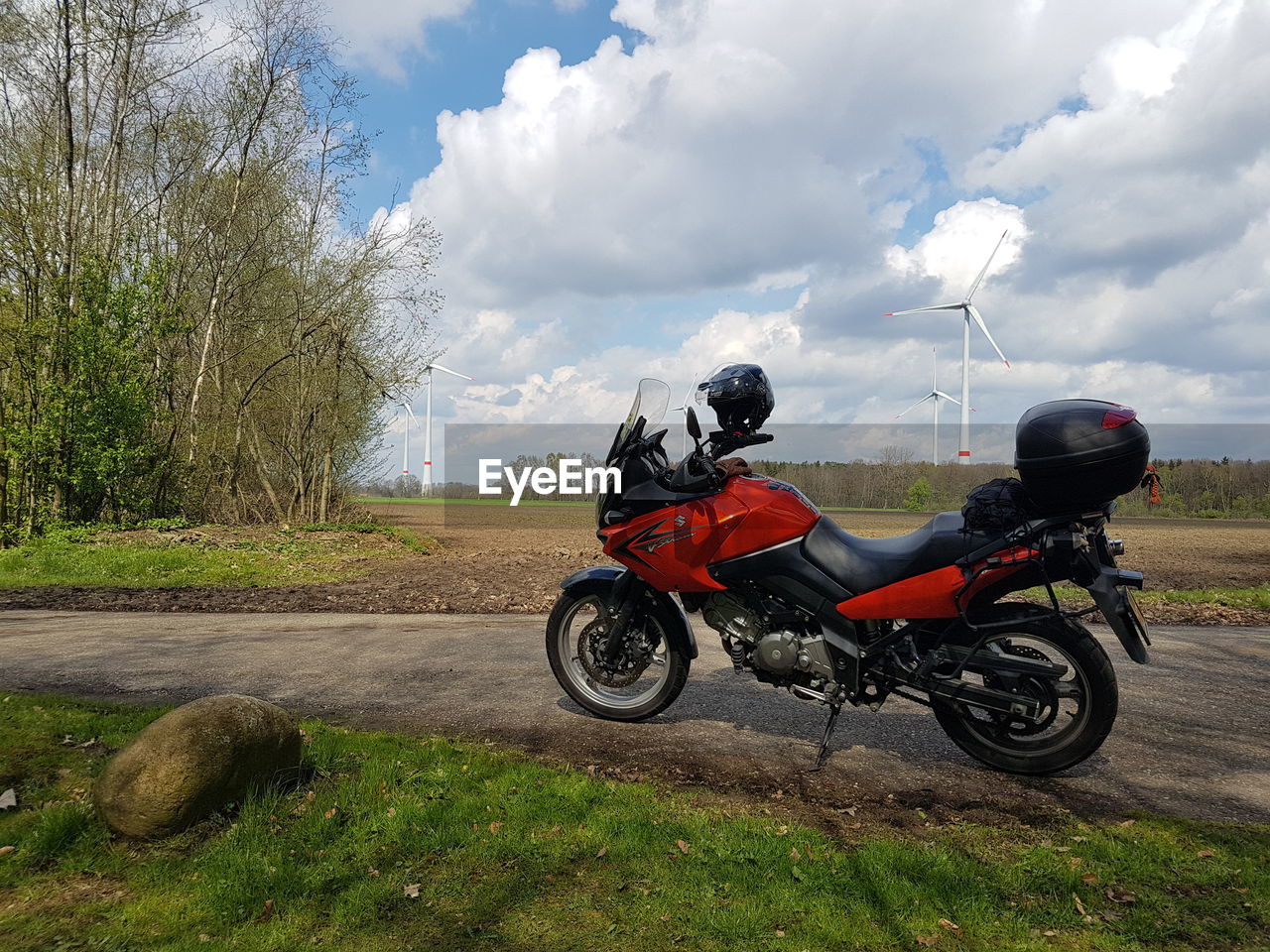 MOTORCYCLE PARKED ON ROAD BY FIELD