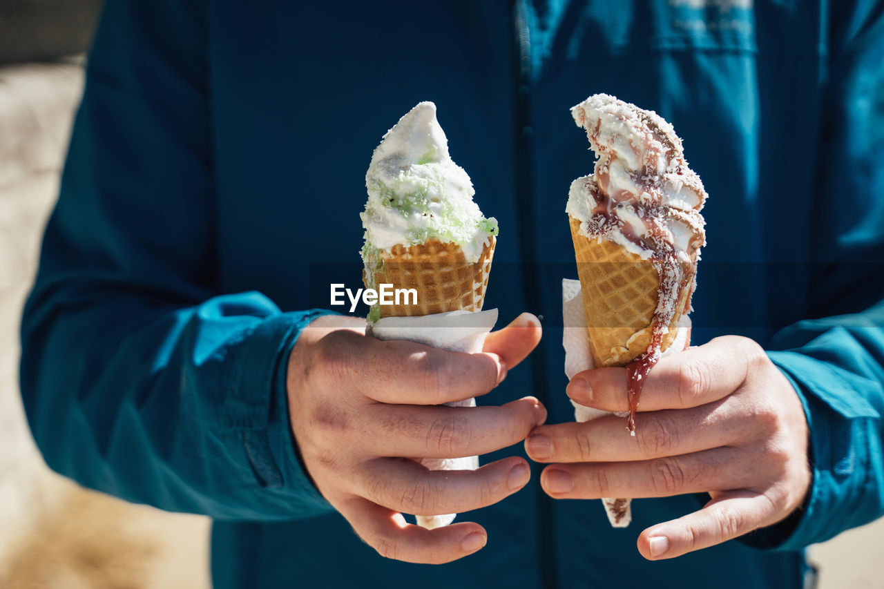 Cropped image of ice cream cone against cake