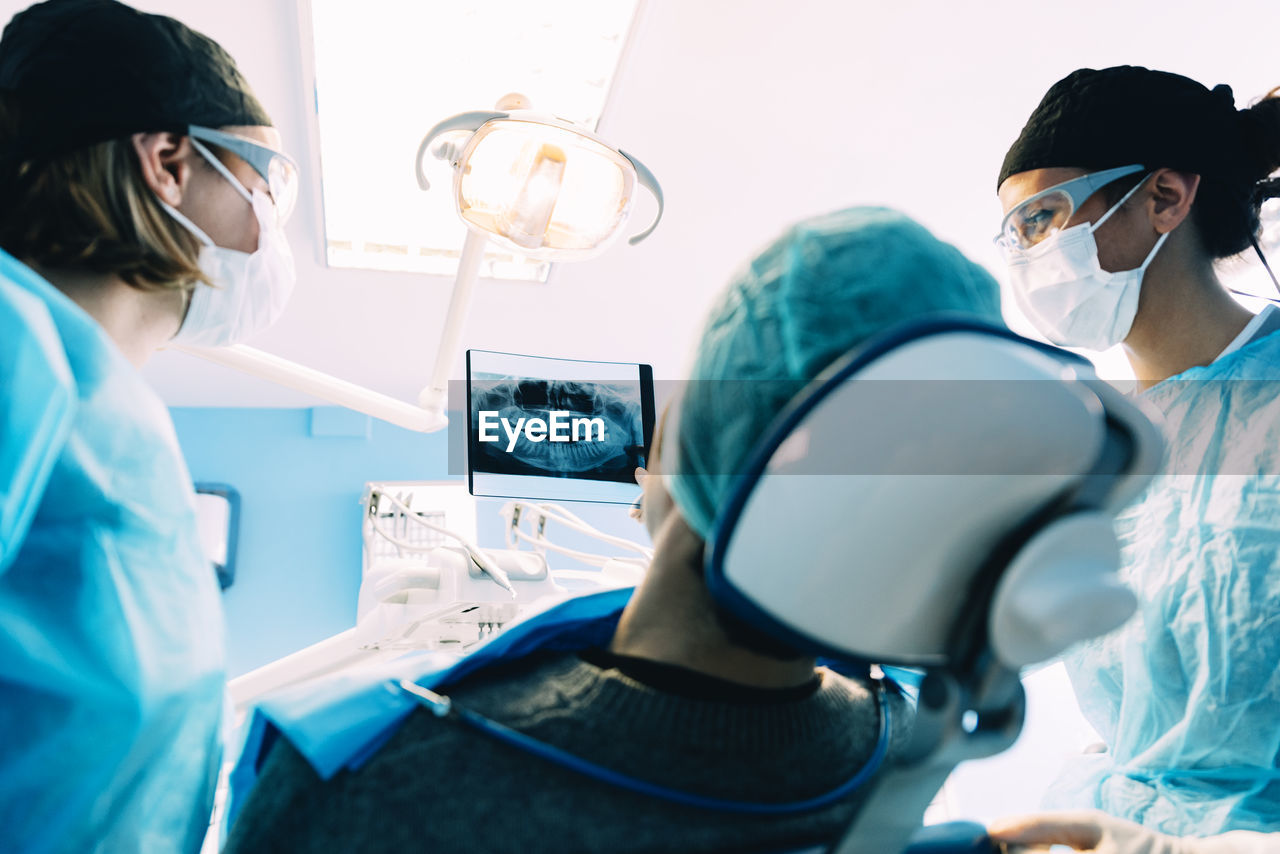 Dentists examining patient in clinic