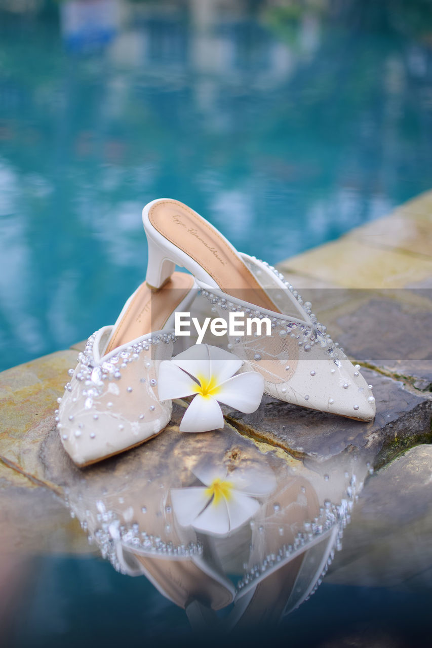 A pair of bride's shoes by the pool