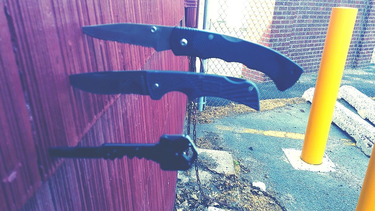 View of three knife poked in wooden wall