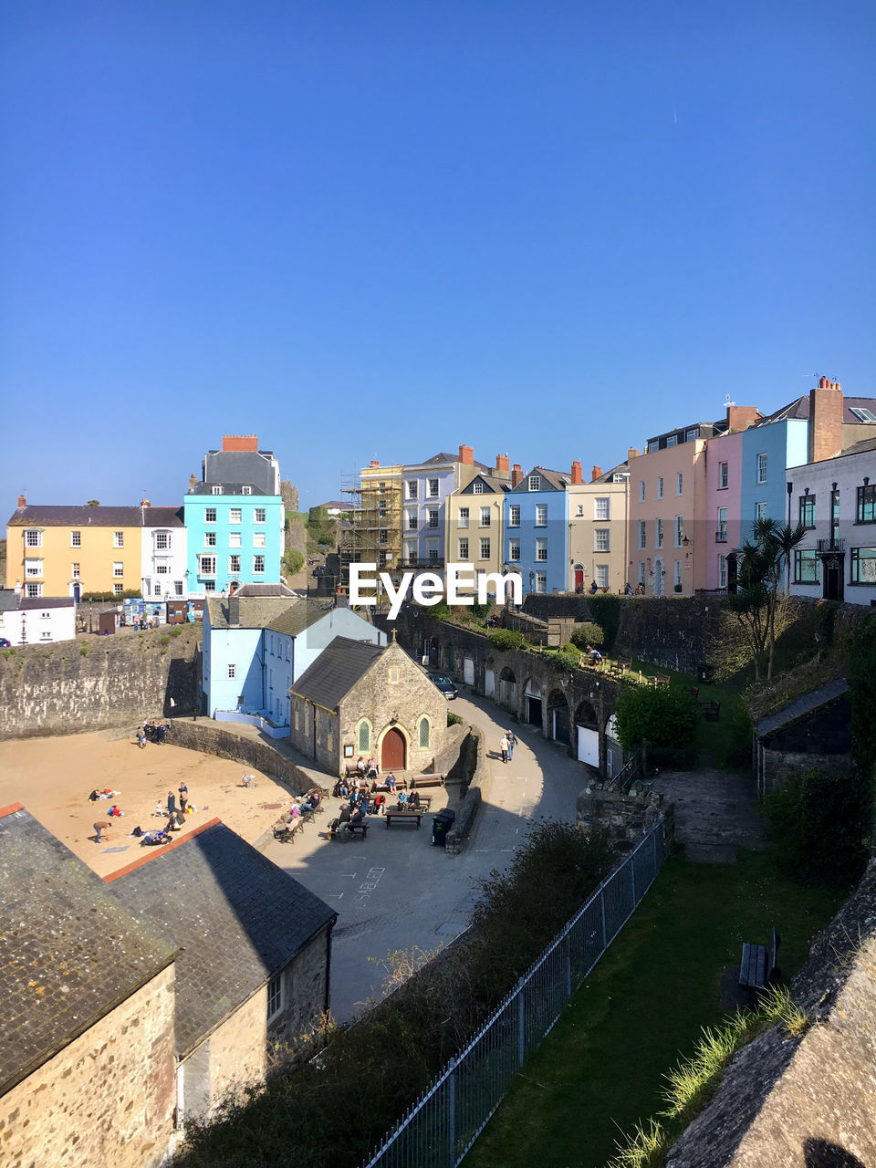 High angle view of buildings by river against clear blue sky