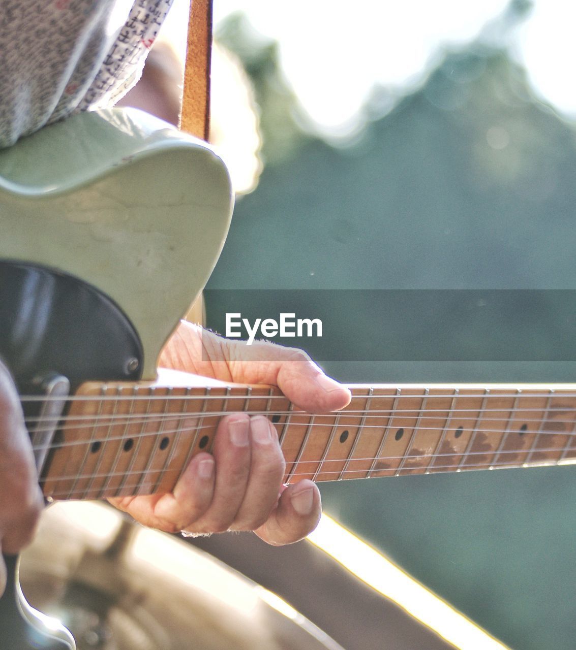 Midsection of man playing guitar