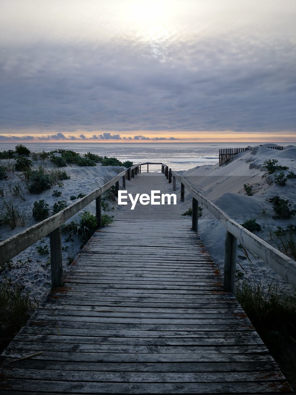 View of pier over sea against sky during sunset