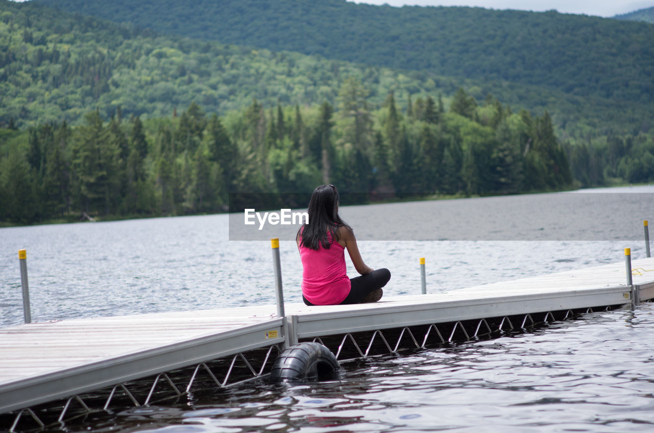 WOMAN ON PIER OVER LAKE